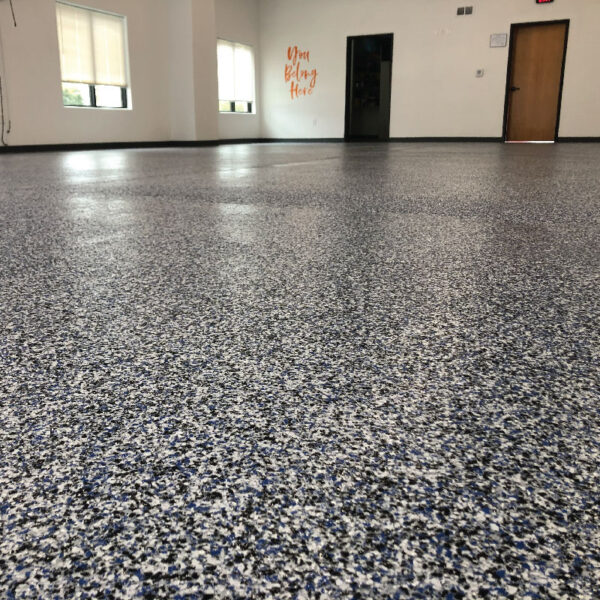 Floor Shield applied in a stylish basement, showcasing durable waterproofing by Dry Otter Foundation Repair.
