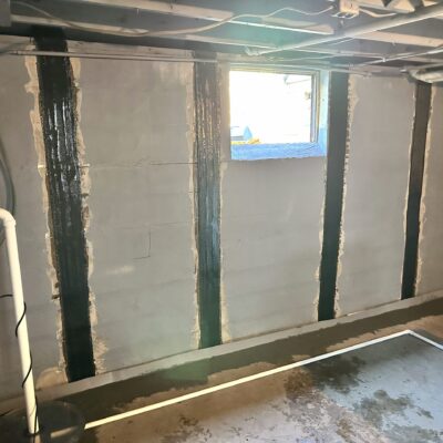 Dry Otter Basement Waterproofing team repairing residential foundation with carbon fiber reinforcement techniques.
